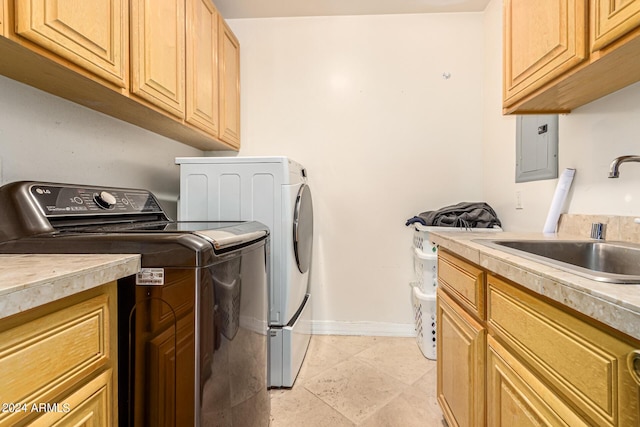 washroom featuring sink, electric panel, cabinets, and washing machine and clothes dryer