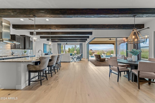 interior space with beam ceiling, light hardwood / wood-style flooring, and a notable chandelier