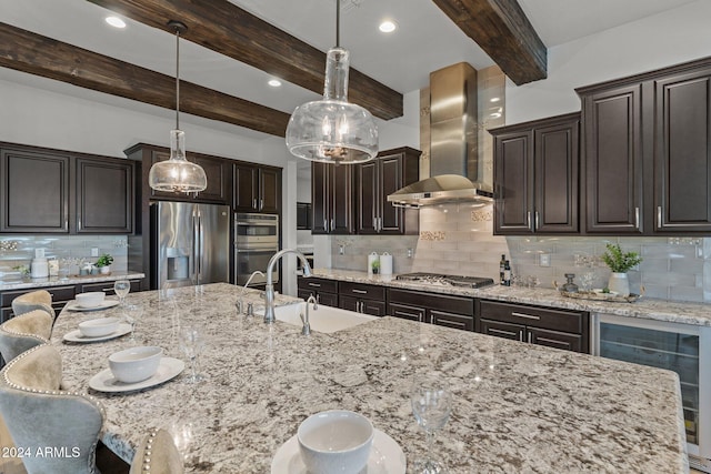 kitchen featuring beamed ceiling, wall chimney range hood, stainless steel appliances, and backsplash