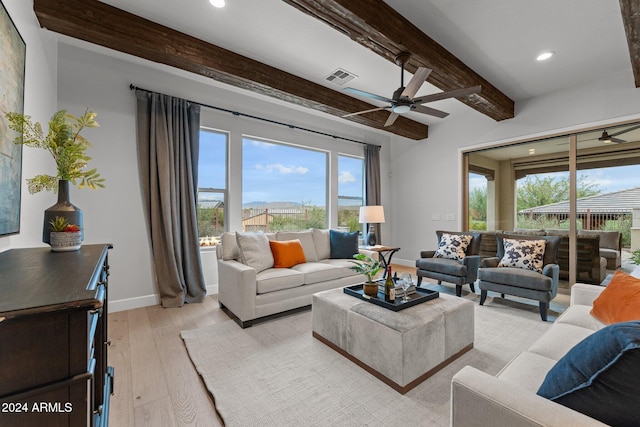 living room featuring beamed ceiling, light hardwood / wood-style flooring, and ceiling fan