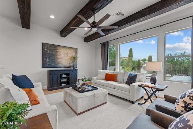 living room featuring ceiling fan, beamed ceiling, and light hardwood / wood-style flooring