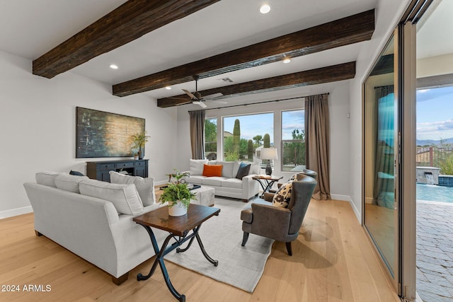 living room featuring light hardwood / wood-style flooring, beam ceiling, and ceiling fan