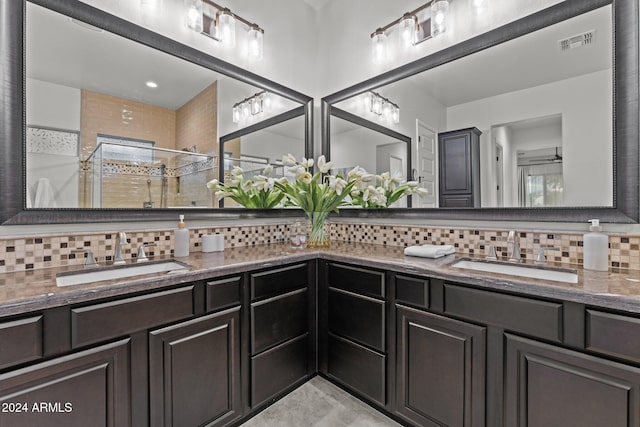 bathroom with vanity, an enclosed shower, and backsplash