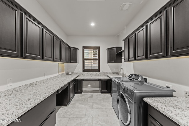 laundry room featuring cabinets, sink, and washer and clothes dryer