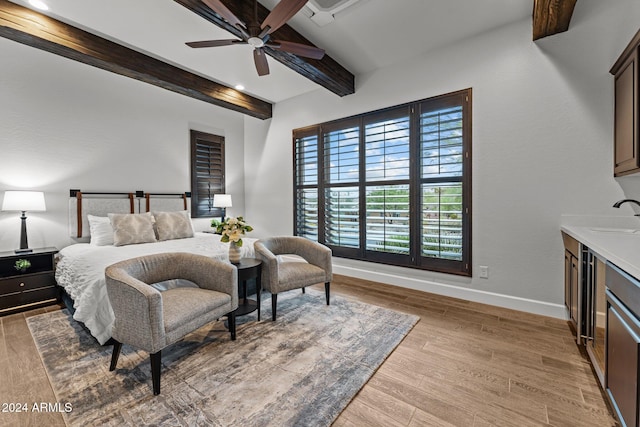 bedroom with ceiling fan, beamed ceiling, sink, and light hardwood / wood-style floors