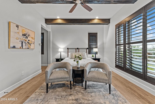 bedroom featuring hardwood / wood-style floors, beam ceiling, and ceiling fan