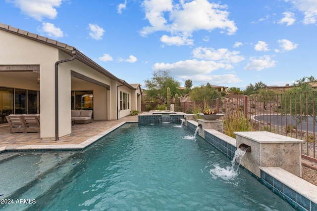 view of pool featuring an in ground hot tub, a patio area, and pool water feature