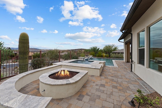 view of swimming pool featuring a patio, a mountain view, and a fire pit