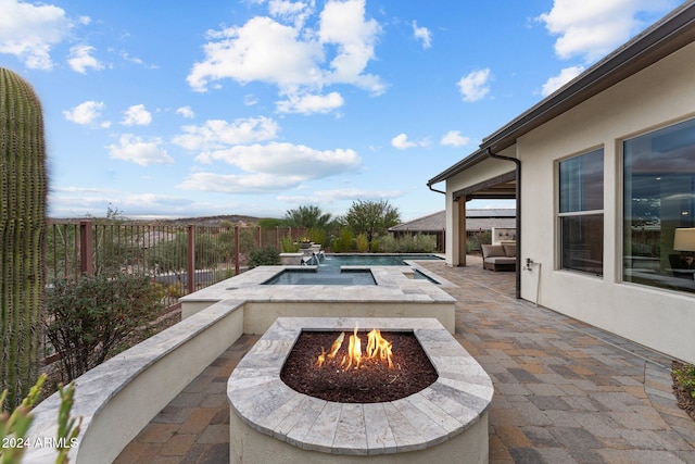 view of patio featuring an outdoor fire pit and a fenced in pool