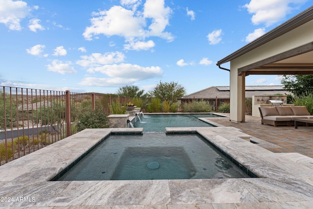 view of pool with an in ground hot tub, pool water feature, and a patio