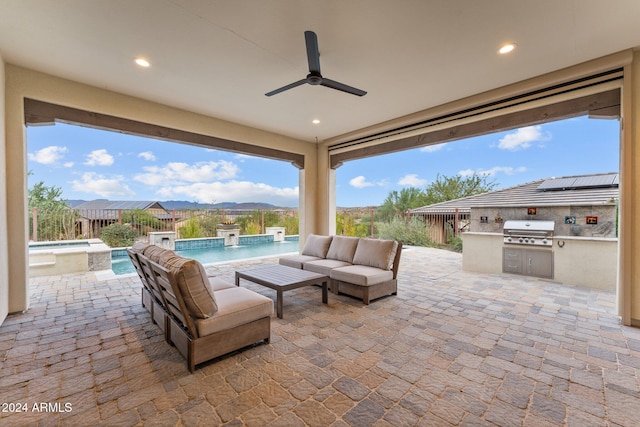 view of patio / terrace featuring area for grilling, exterior kitchen, pool water feature, a fenced in pool, and an outdoor living space