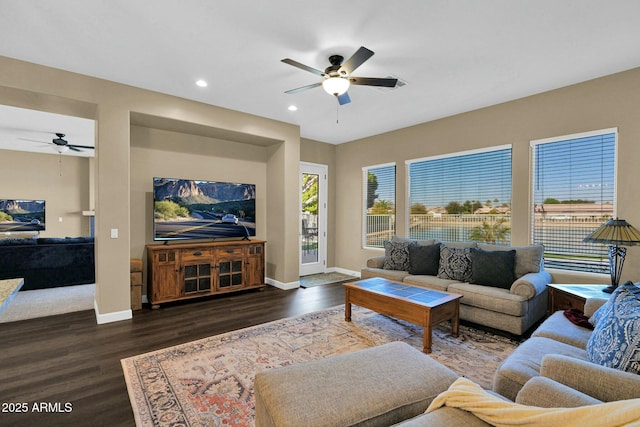 living room featuring ceiling fan and dark hardwood / wood-style flooring