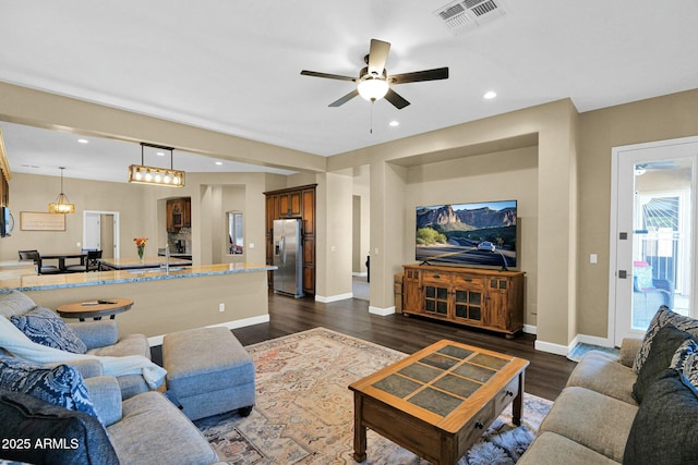 living room featuring ceiling fan and dark hardwood / wood-style flooring