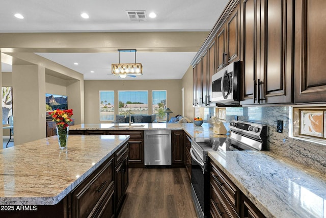 kitchen with sink, decorative light fixtures, dark brown cabinets, appliances with stainless steel finishes, and kitchen peninsula