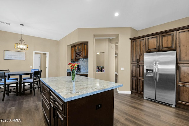 kitchen featuring dark brown cabinetry, decorative light fixtures, a kitchen island, and stainless steel refrigerator with ice dispenser