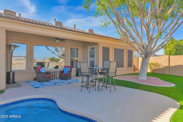 rear view of property featuring ceiling fan and a patio