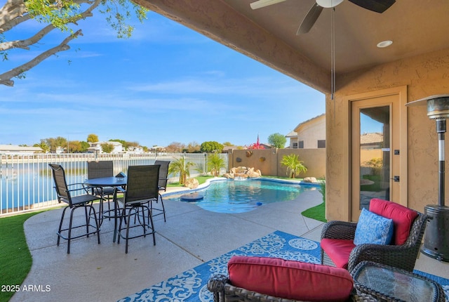 view of pool with a water view, ceiling fan, and a patio area