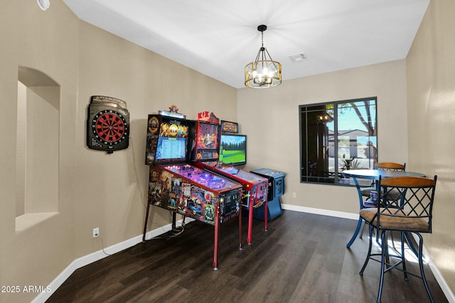 dining space featuring dark wood-type flooring and a chandelier