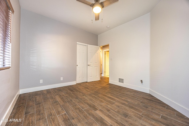 spare room with dark hardwood / wood-style flooring and ceiling fan