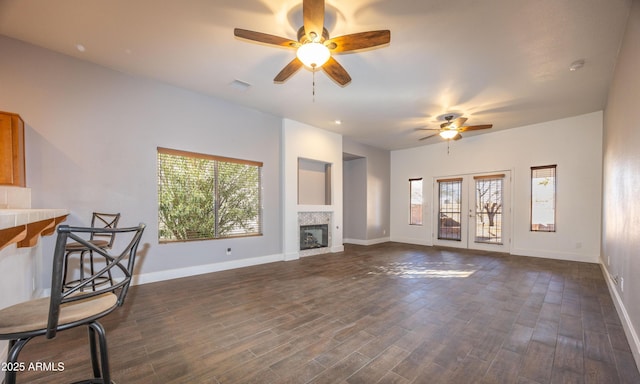 unfurnished living room featuring dark wood-type flooring, a fireplace, and ceiling fan