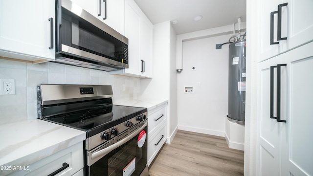 1838 E Earll Dr, Phoenix, AZ 85016 - kitchen featuring tasteful backsplash, electric water heater, light wood-style floors, stainless steel appliances, and white cabinets