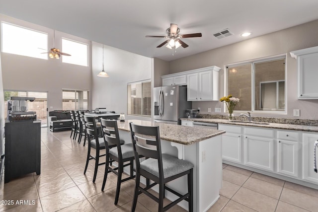 kitchen featuring white cabinetry, appliances with stainless steel finishes, sink, and light stone counters