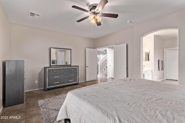 tiled bedroom with ensuite bathroom and ceiling fan