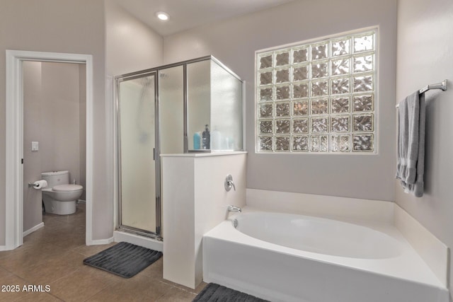 bathroom with tile patterned flooring, separate shower and tub, and toilet