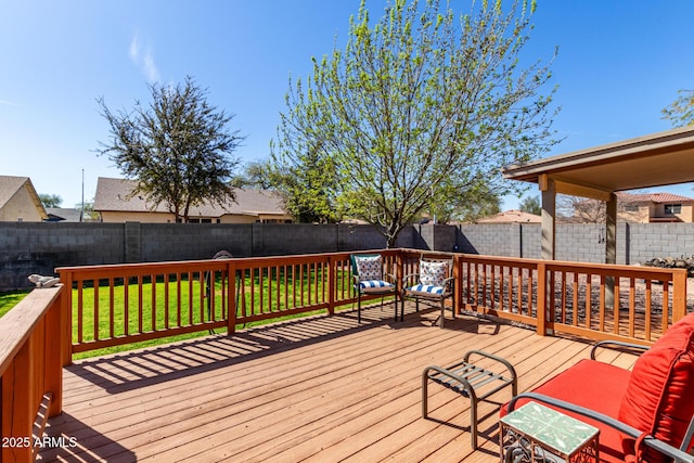 wooden terrace featuring a fenced backyard and a lawn