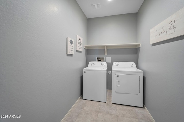 clothes washing area with independent washer and dryer and light tile patterned flooring