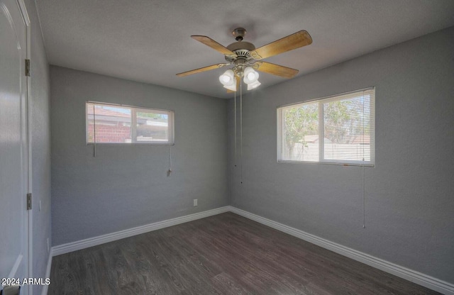 unfurnished room featuring dark wood-type flooring, ceiling fan, plenty of natural light, and a textured ceiling