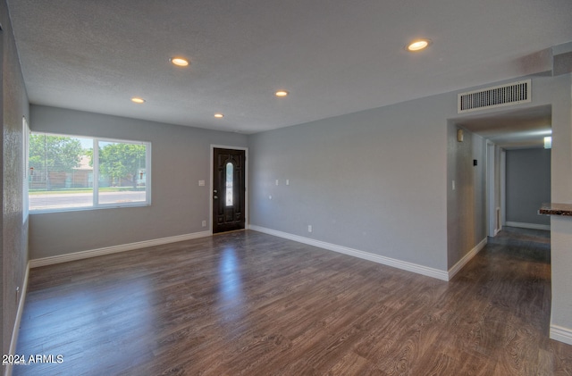 empty room featuring dark hardwood / wood-style floors and a textured ceiling