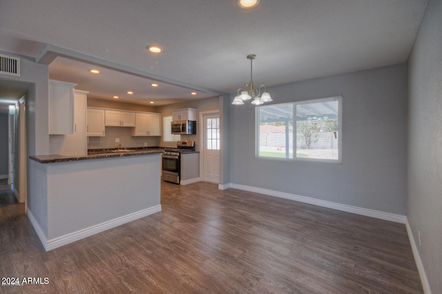 kitchen featuring an inviting chandelier, dark hardwood / wood-style floors, pendant lighting, stainless steel appliances, and white cabinets