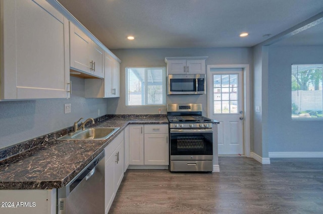 kitchen featuring appliances with stainless steel finishes, white cabinetry, plenty of natural light, and sink