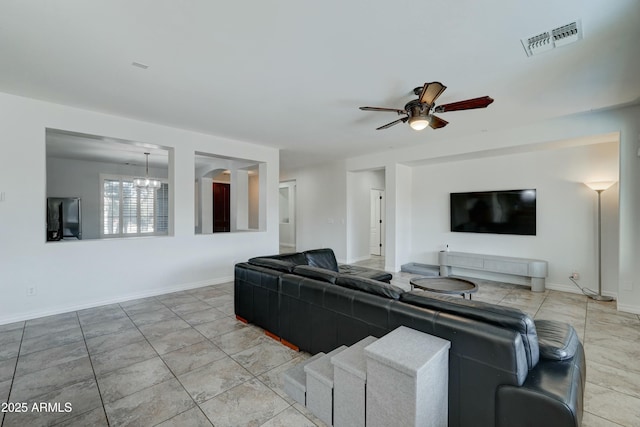 living room with ceiling fan with notable chandelier