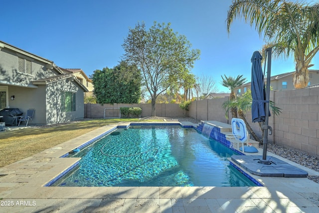 view of swimming pool featuring pool water feature, grilling area, and a yard