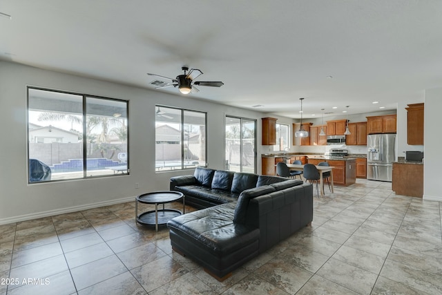 living room featuring light tile patterned floors, sink, and ceiling fan