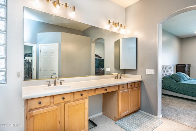 full bathroom with tile patterned floors, double vanity, baseboards, and a sink