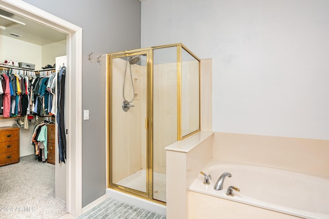 bathroom featuring a shower stall, a spacious closet, and a bath