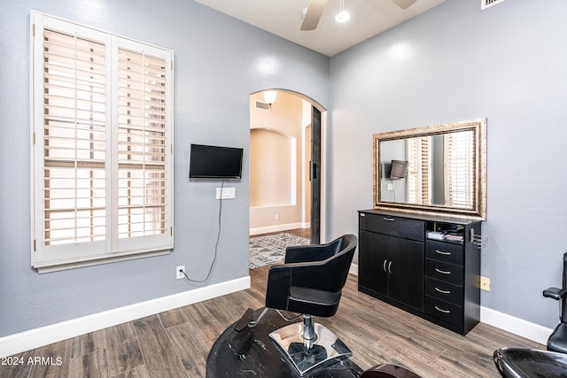 living area with visible vents, wood finished floors, arched walkways, baseboards, and ceiling fan