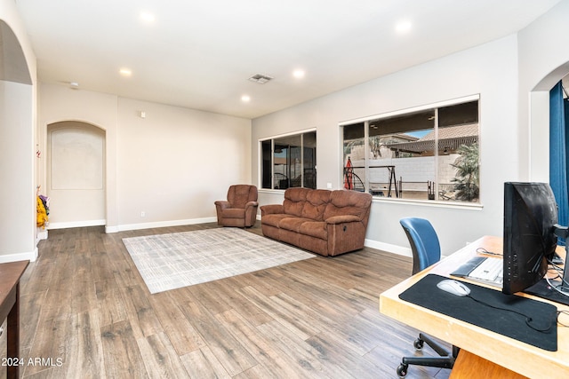 home office with recessed lighting, visible vents, arched walkways, and wood finished floors