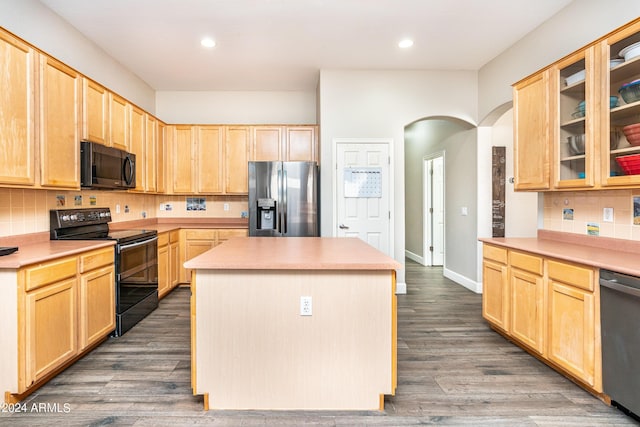 kitchen featuring arched walkways, black appliances, a center island, and light brown cabinets