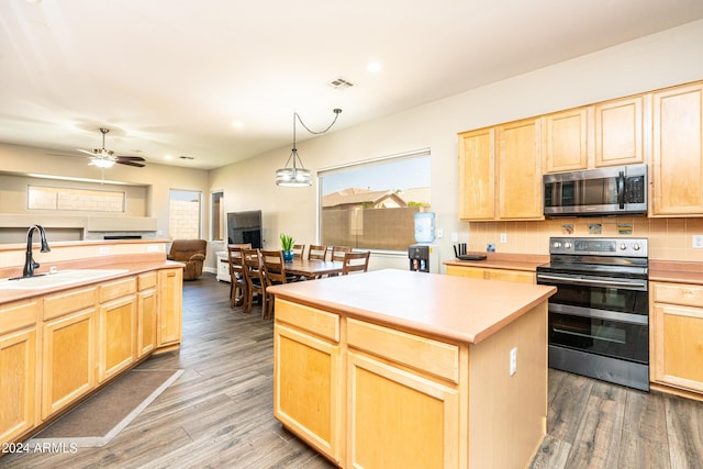 kitchen with light brown cabinets, visible vents, appliances with stainless steel finishes, and a sink