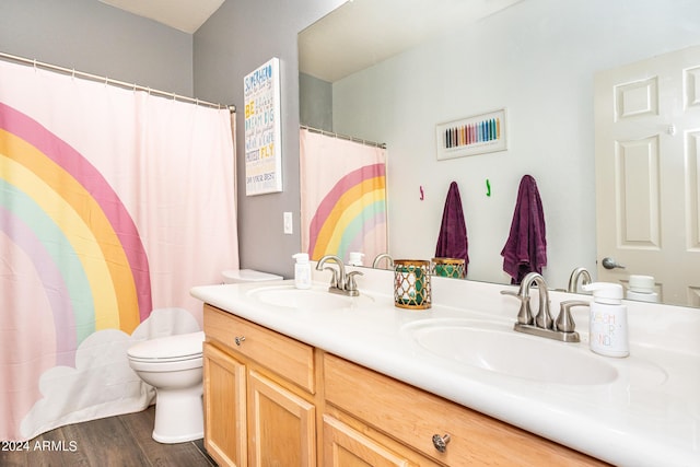 full bathroom with double vanity, wood finished floors, toilet, and a sink