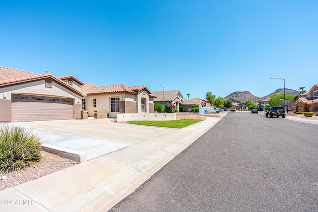 exterior space featuring stucco siding, driveway, a tile roof, a residential view, and an attached garage