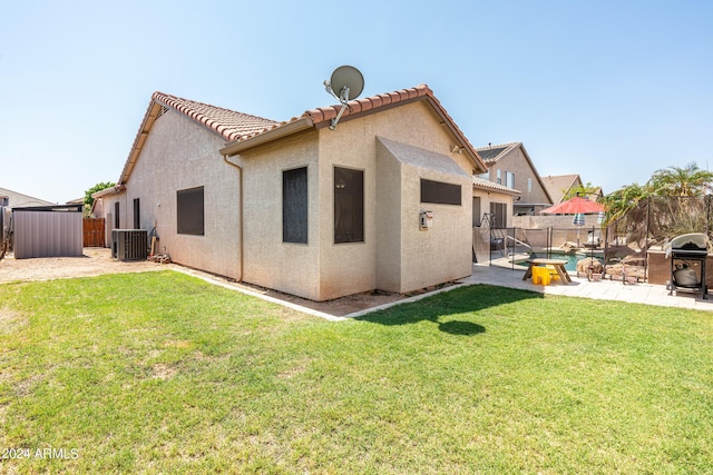 rear view of house with a fenced backyard, stucco siding, central AC, and a patio