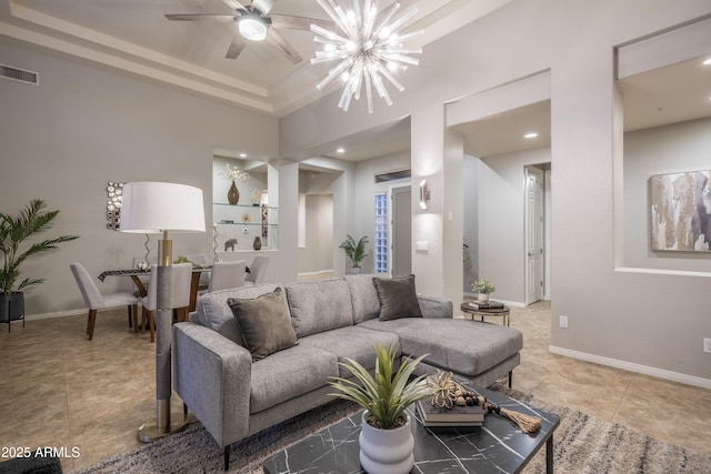 living area with baseboards, light tile patterned flooring, visible vents, and ceiling fan with notable chandelier