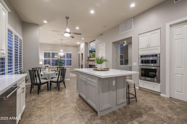 kitchen with light countertops, recessed lighting, ceiling fan with notable chandelier, visible vents, and appliances with stainless steel finishes