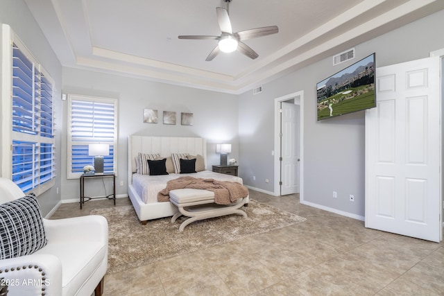 bedroom featuring a tray ceiling, baseboards, visible vents, and ceiling fan