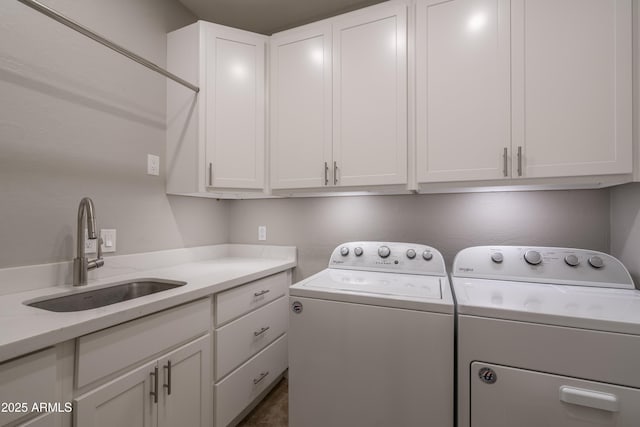 laundry room with washer and clothes dryer, cabinet space, and a sink